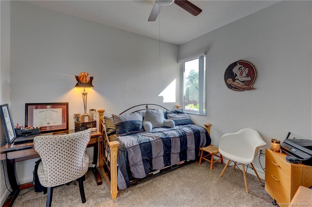 55 Southeast Palermo, Unit 102 Stuart, FL 34994 - Photo 15 of 40 a bedroom with a bed and a chandelier