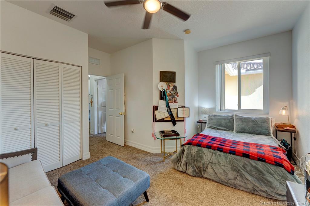 55 Southeast Palermo, Unit 102 Stuart, FL 34994 - Photo 18 of 40 a bedroom with a bed and a chandelier