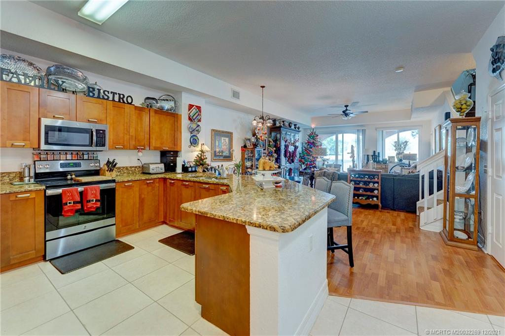 55 Southeast Palermo, Unit 102 Stuart, FL 34994 - Photo 25 of 40 a kitchen with stainless steel appliances granite countertop a sink counter space cabinets and a window