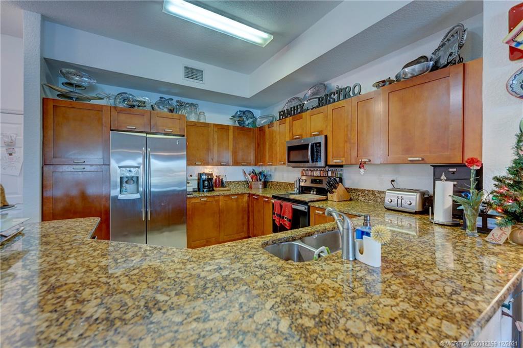 55 Southeast Palermo, Unit 102 Stuart, FL 34994 - Photo 27 of 40 a kitchen with stainless steel appliances granite countertop a sink stove and refrigerator