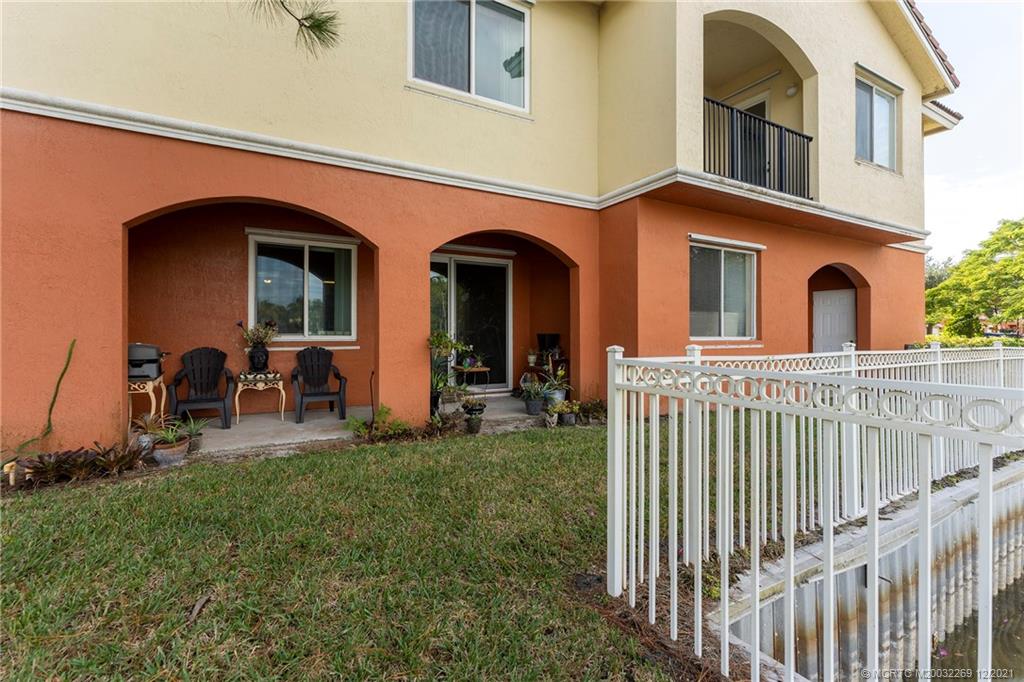 55 Southeast Palermo, Unit 102 Stuart, FL 34994 - Photo 32 of 40 a view of a brick house with many windows next to a yard