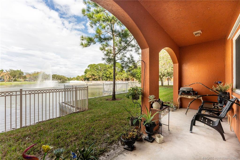 55 Southeast Palermo, Unit 102 Stuart, FL 34994 - Photo 34 of 40 a view of a patio with table and chairs next to a yard