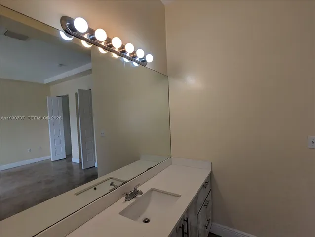 a bathroom with a sink vanity and a mirror