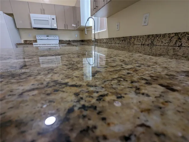 a kitchen with granite countertop a sink and a stove