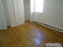 a view of a room with wooden floor and a window