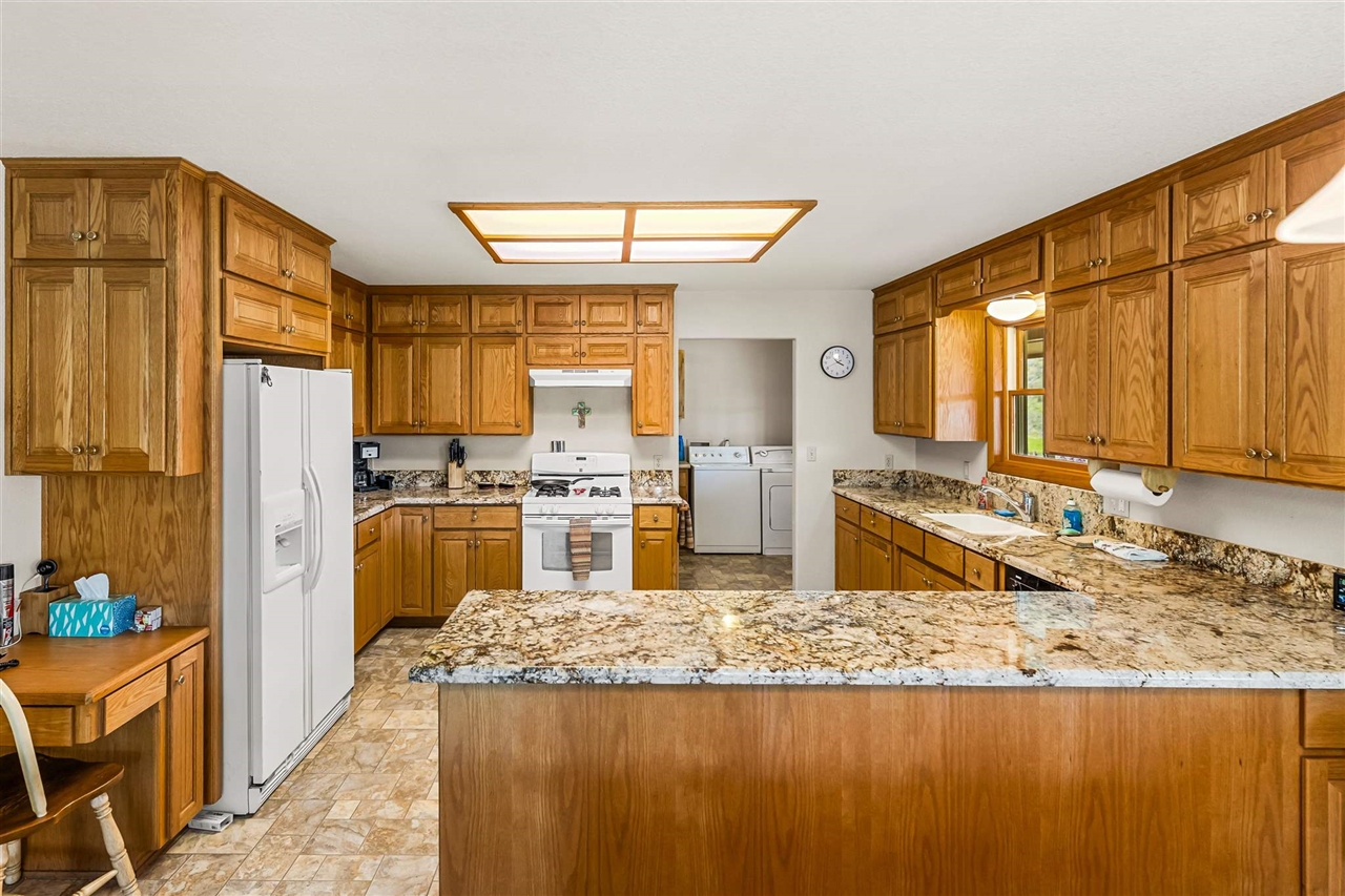 16554 Cocoran Gray Road Groveland, CA 95321 - Photo 11 of 38 Kitchen with kitchen peninsula, white appliances, washing machine and clothes dryer, sink, and light tile floors