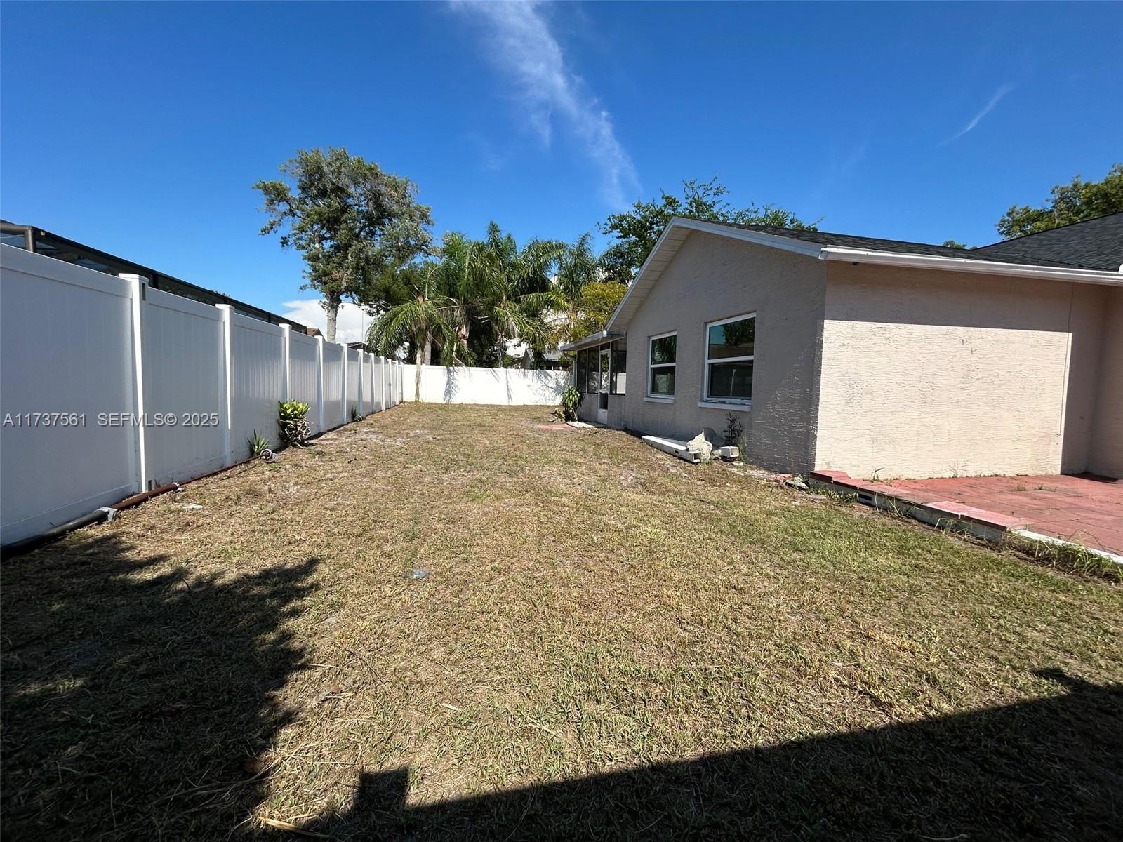 7403 Foxbloom Drive Port Richey, FL 34668 - Photo 26 of 45 a front view of house with yard and trees in the background
