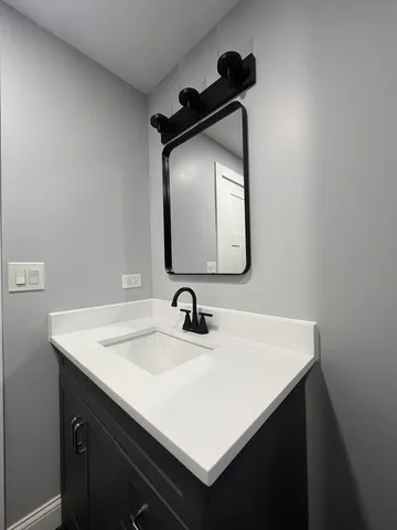 a bathroom with a sink vanity and a mirror