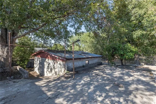 a view of a wooden house with large trees