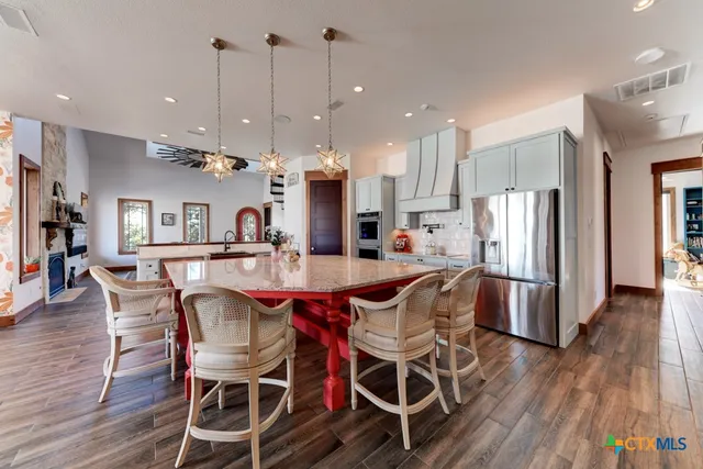 a large kitchen with stainless steel appliances kitchen island granite countertop a large island in the center