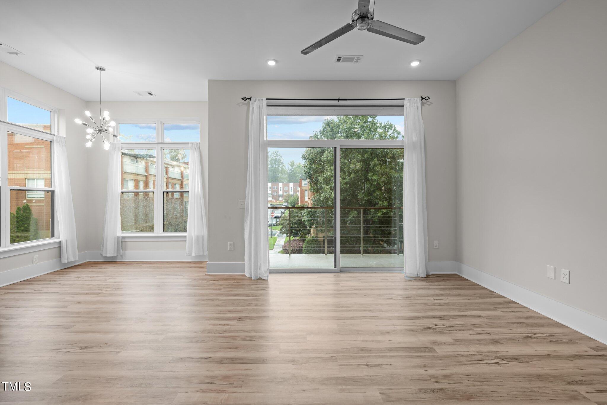 2441 Campus Shore Drive, Unit 312 Raleigh, NC 27606 - Photo 12 of 43 a view of an empty room with wooden floor and a window