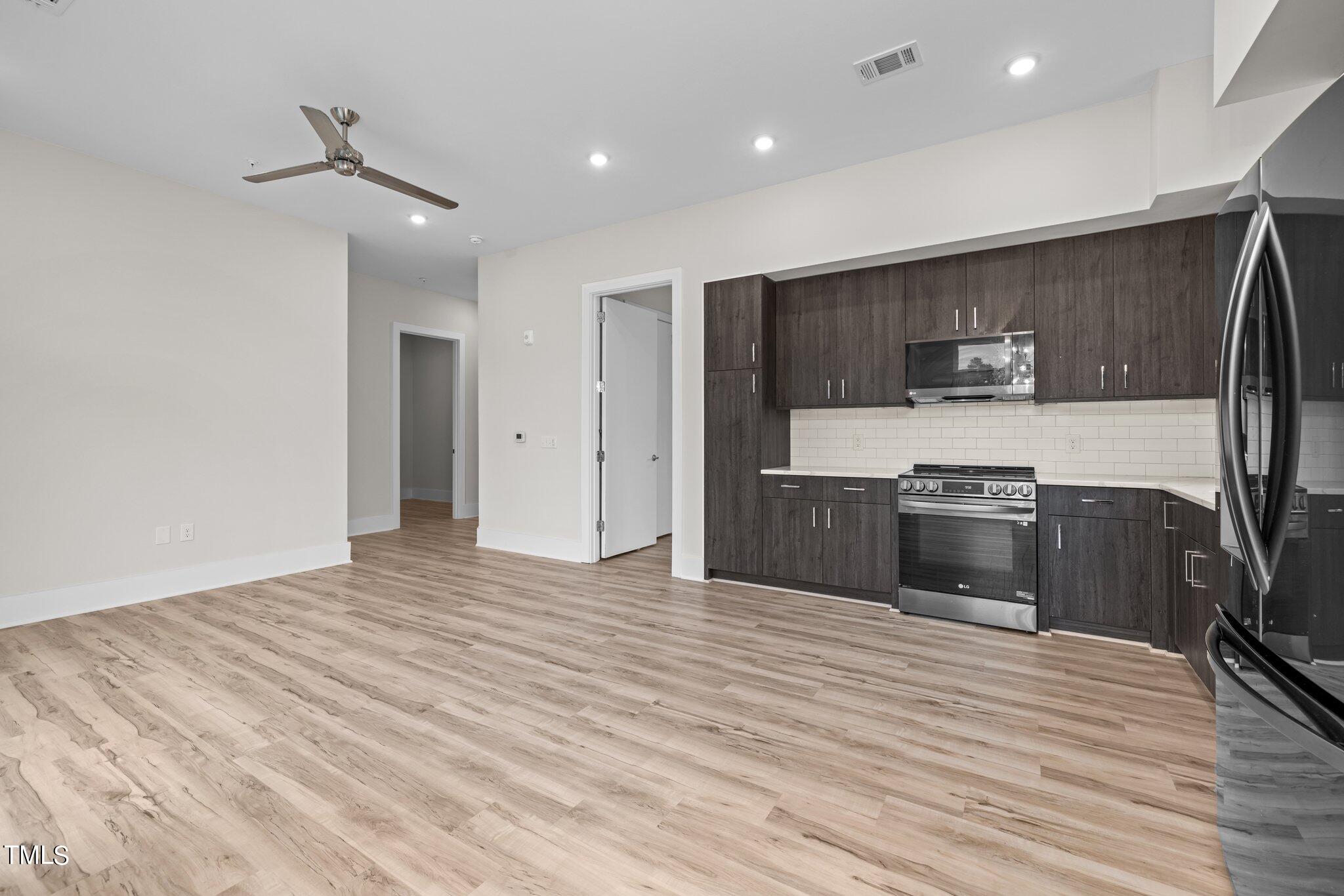 2441 Campus Shore Drive, Unit 312 Raleigh, NC 27606 - Photo 13 of 43 a kitchen with stainless steel appliances a stove top oven a sink and a refrigerator