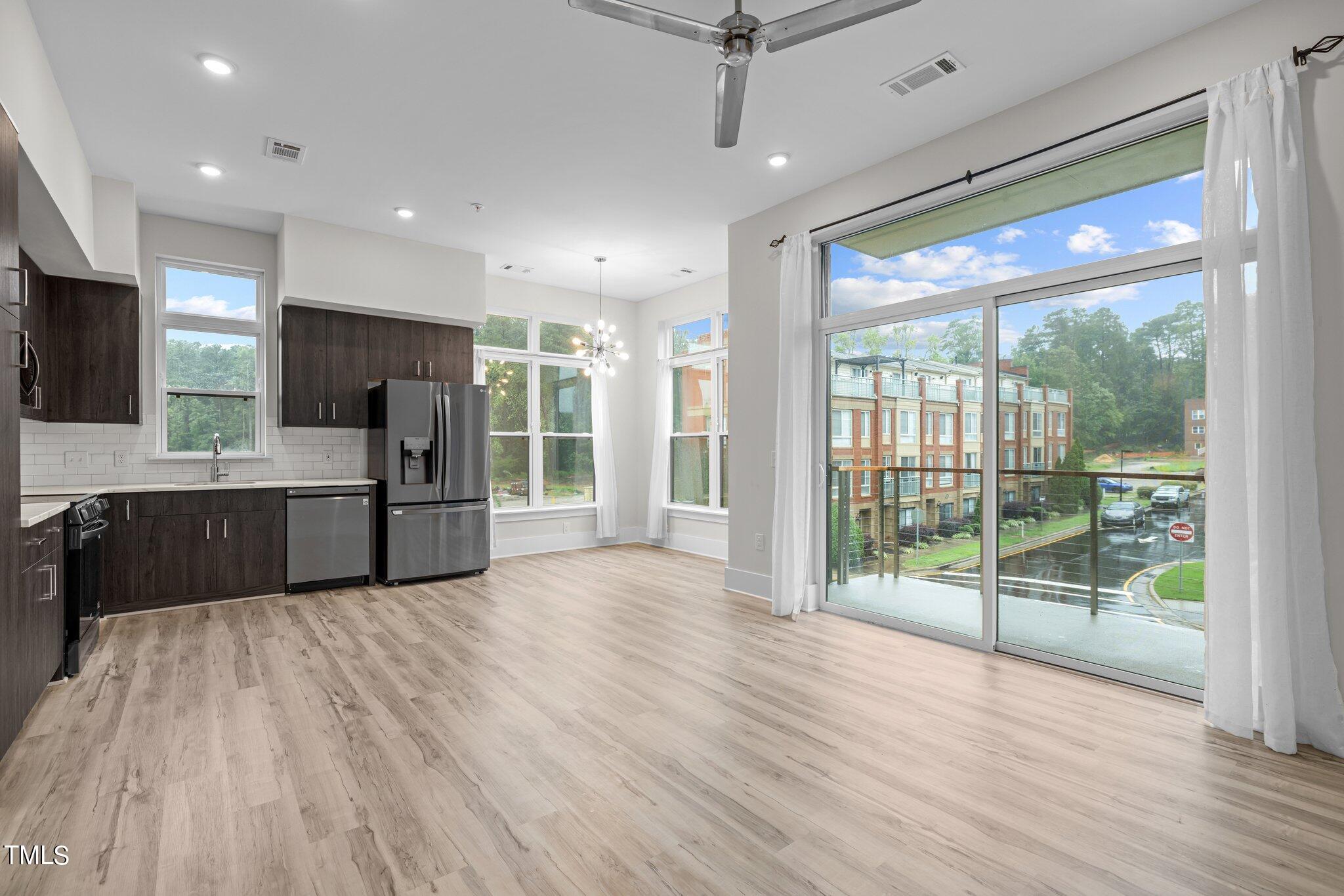2441 Campus Shore Drive, Unit 312 Raleigh, NC 27606 - Photo 2 of 43 a large kitchen with stainless steel appliances a large counter top a sink a stove a refrigerator and cabinets