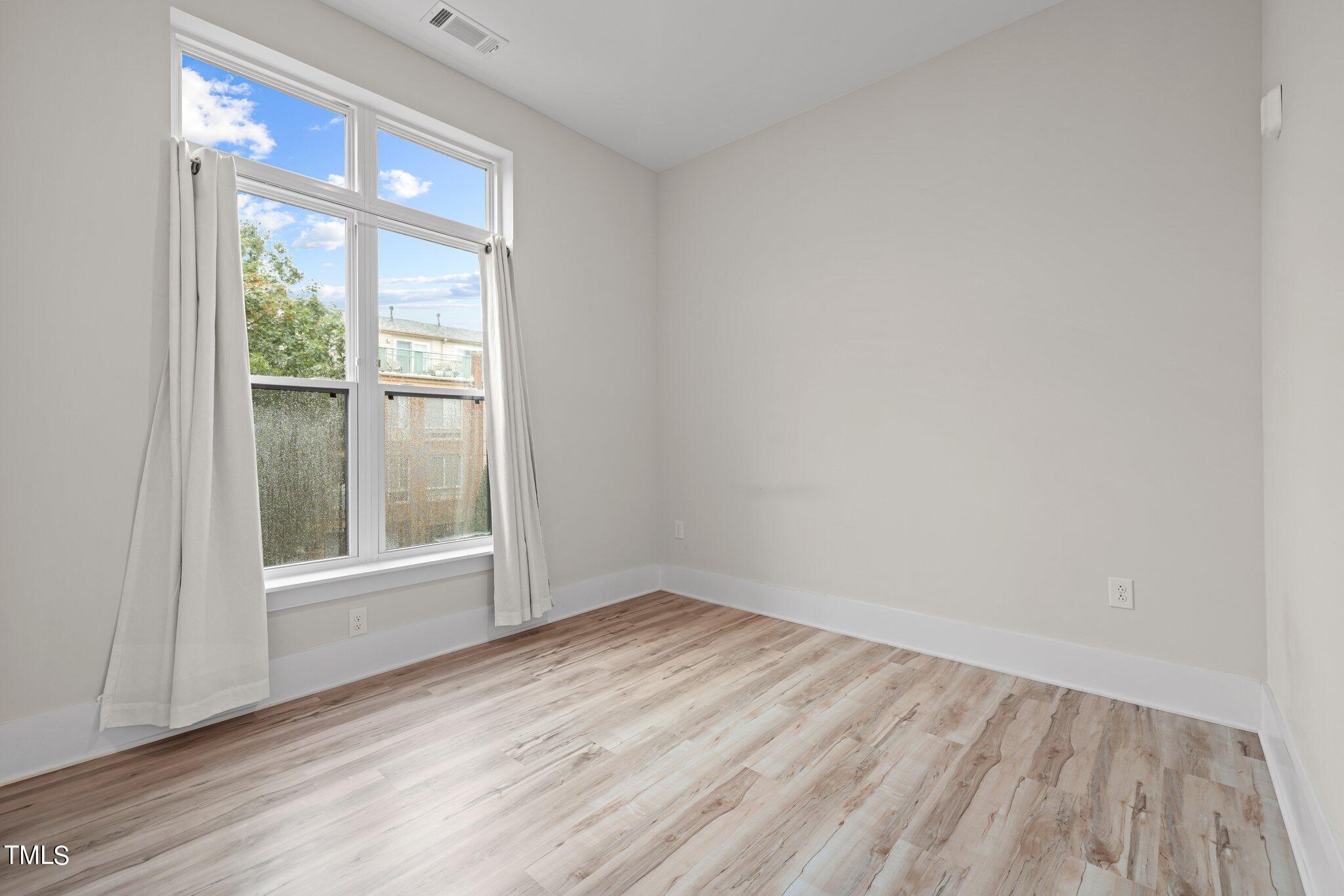 2441 Campus Shore Drive, Unit 312 Raleigh, NC 27606 - Photo 35 of 43 an empty room with wooden floor and windows