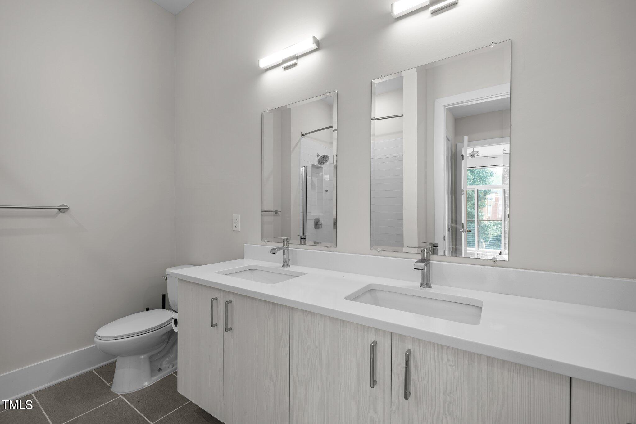 2441 Campus Shore Drive, Unit 312 Raleigh, NC 27606 - Photo 39 of 43 a bathroom with a sink toilet and mirror