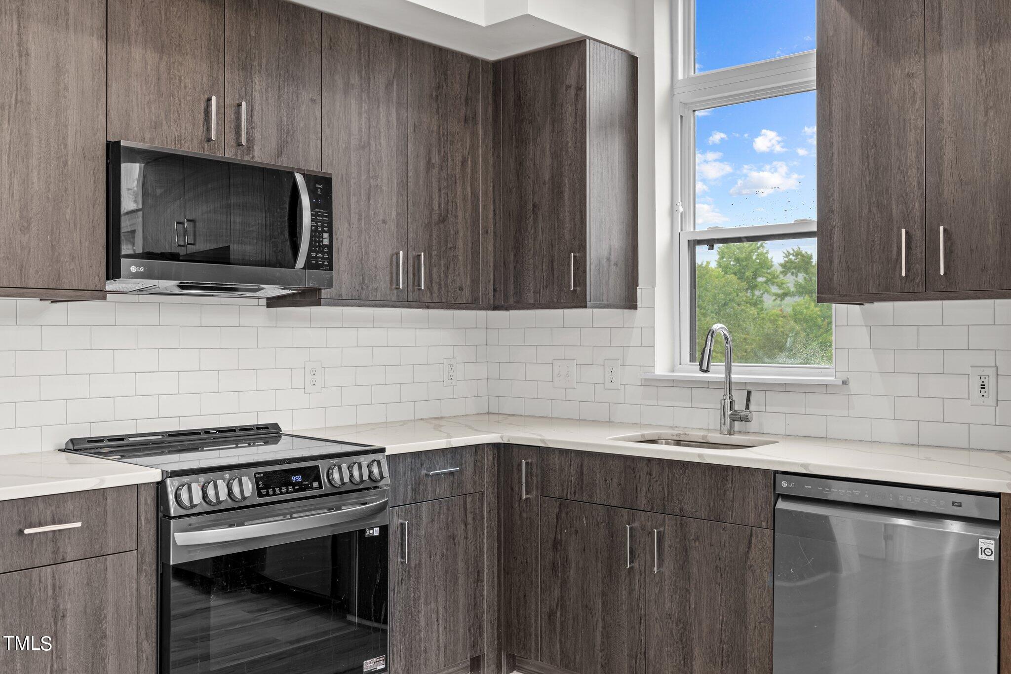 2441 Campus Shore Drive, Unit 312 Raleigh, NC 27606 - Photo 5 of 43 a kitchen with a sink stove and microwave