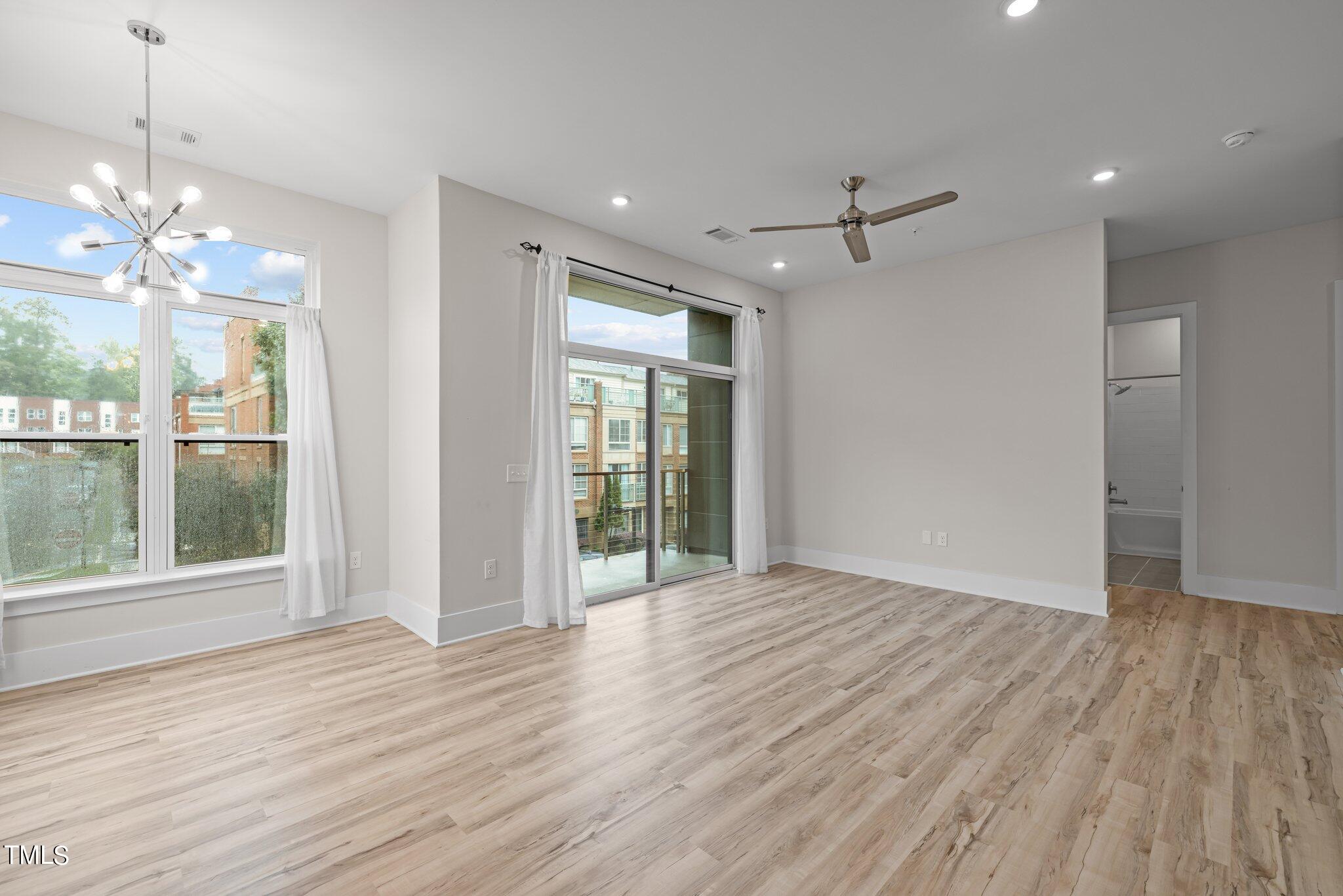 2441 Campus Shore Drive, Unit 312 Raleigh, NC 27606 - Photo 6 of 43 a view of an empty room with wooden floor and a window