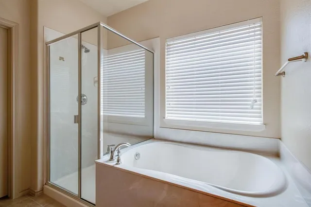 a white bath tub sitting in a bathroom next to a window