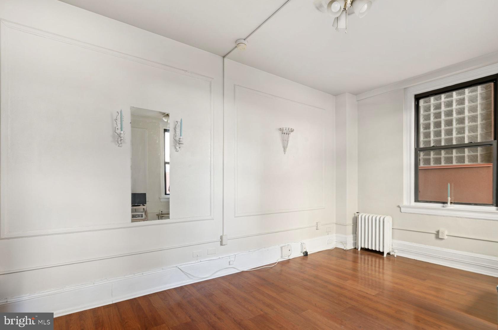1324 Locust Street, Unit 619 Philadelphia, PA 19107 - Photo 7 of 19 an empty room with wooden floor and windows