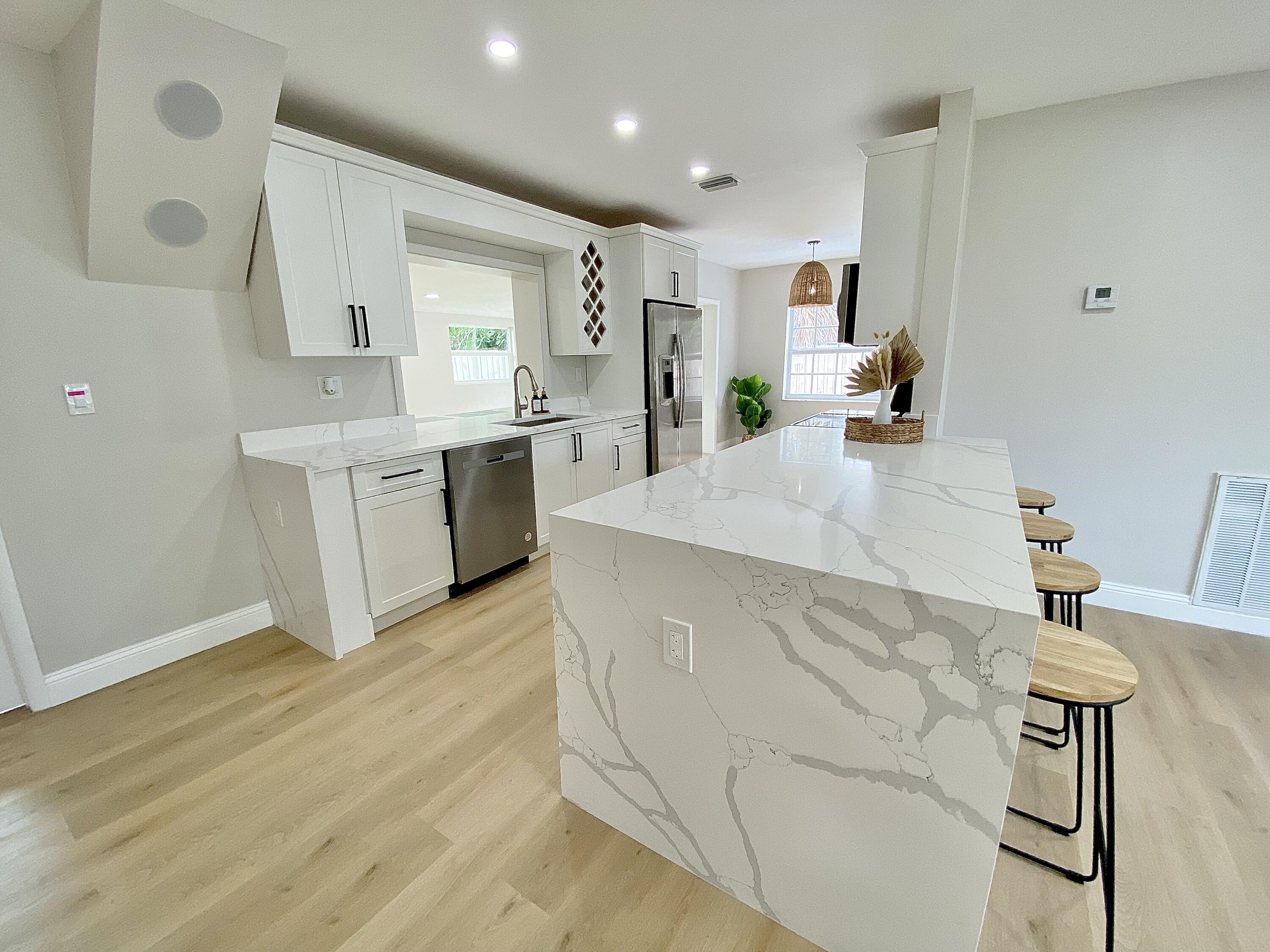 500 Southwest 3rd Avenue Boca Raton, FL 33432 - Photo 11 of 39 a large white kitchen with wooden floor and stainless steel appliances