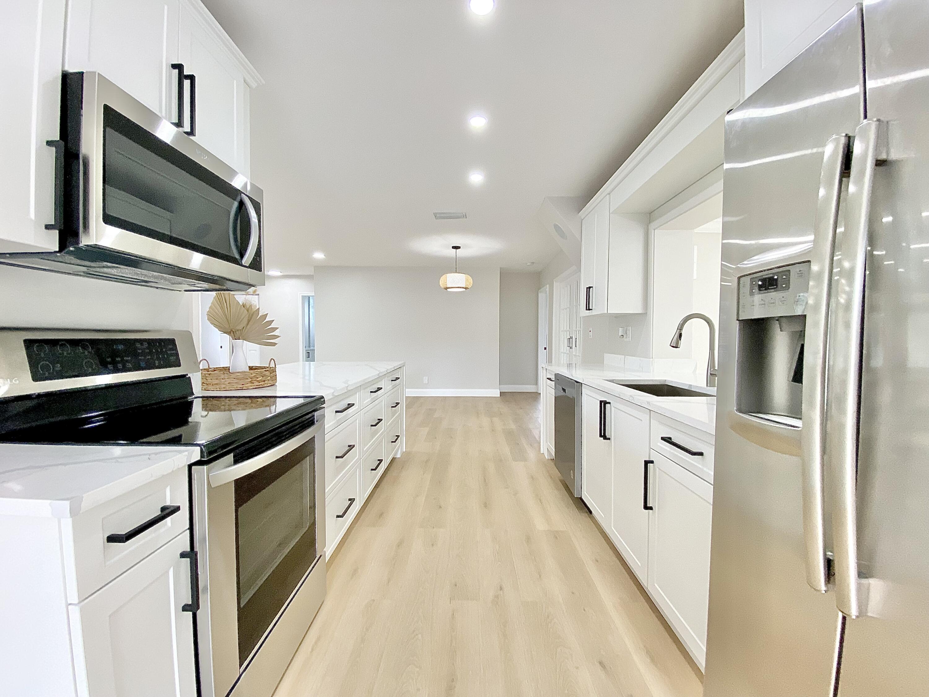 500 Southwest 3rd Avenue Boca Raton, FL 33432 - Photo 25 of 39 a white kitchen with stainless steel appliances and white cabinets