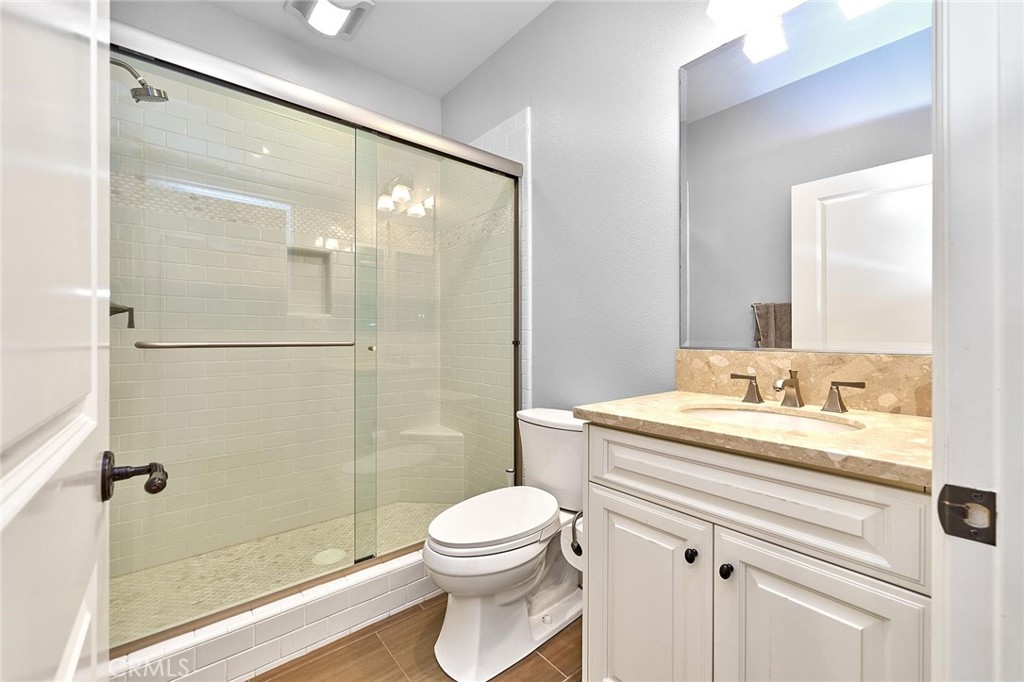 57 Statuary Irvine, CA 92620 - Photo 24 of 66 a bathroom with a granite countertop sink toilet a mirror and shower