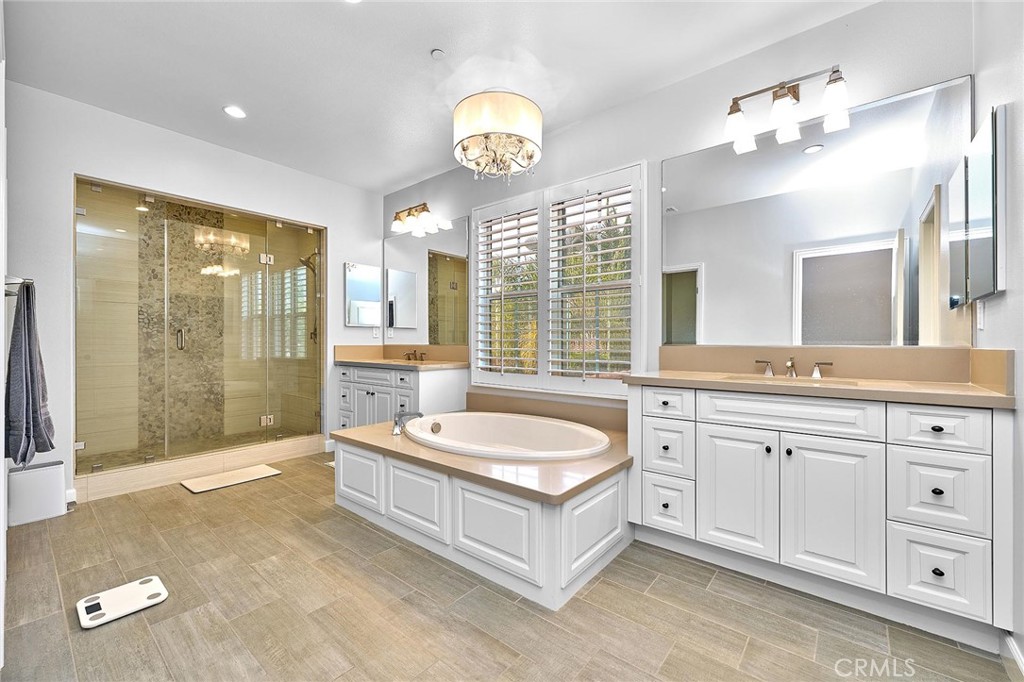 57 Statuary Irvine, CA 92620 - Photo 45 of 66 a spacious bathroom with a granite countertop tub a double vanity sink and a mirror