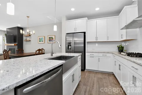 a kitchen with granite countertop a sink stove and refrigerator