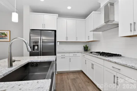 a kitchen with granite countertop white cabinets and stainless steel appliances
