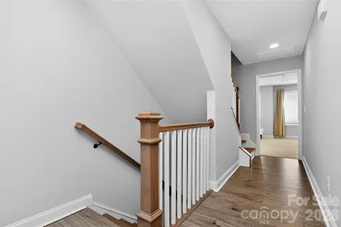 a view of a hallway with a white walls and wooden floor