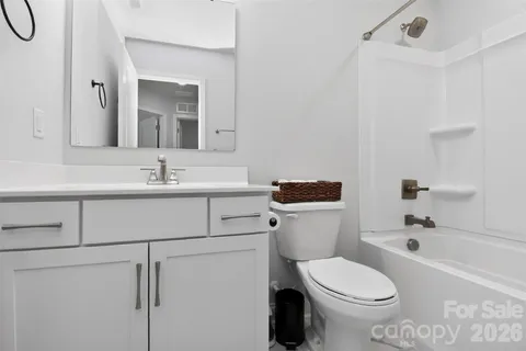 a bathroom with a sink toilet vanity and tub