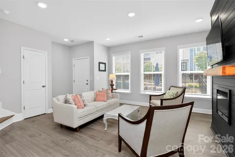 a living room with furniture a fireplace and a flat screen tv