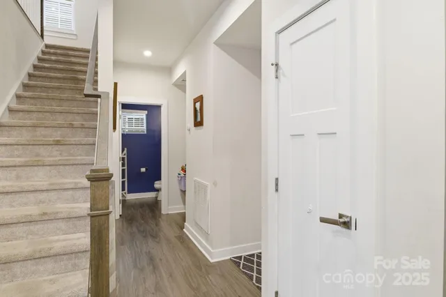 a view of a hallway with wooden floor and staircase