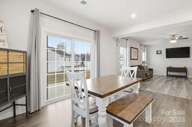 a living room with furniture a flat screen tv and wooden floor