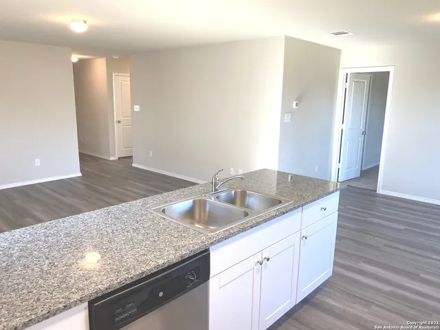 a kitchen with granite countertop a sink and wooden cabinets