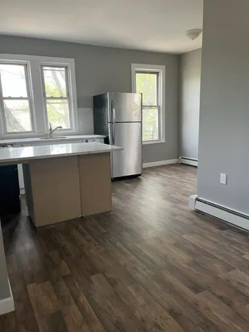 an empty room with wooden floor and a window