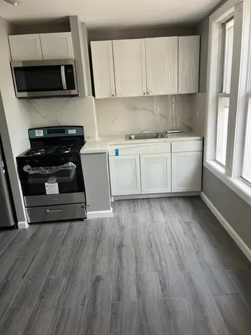 a kitchen with a sink a microwave and cabinets