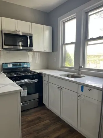 a kitchen with stainless steel appliances a stove a microwave a sink and cabinets