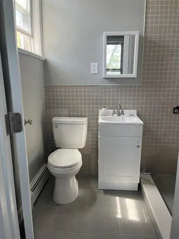 a bathroom with a toilet sink and mirror