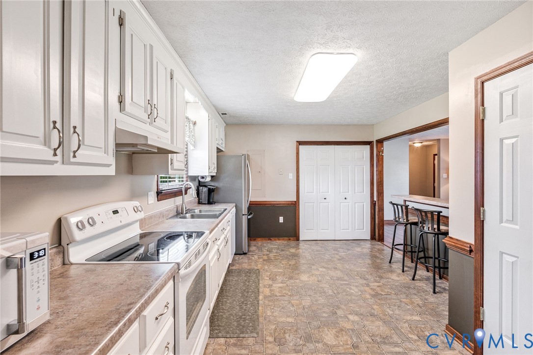 3411 Spring Run Road Mechanicsville, VA 23111 - Photo 22 of 41 a kitchen with stainless steel appliances granite countertop a refrigerator a stove and a sink with cabinets