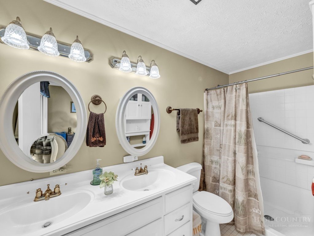 265 Trout Lake Road Deep Gap, NC 28618 - Photo 22 of 50 a bathroom with a sink mirror vanity and toilet