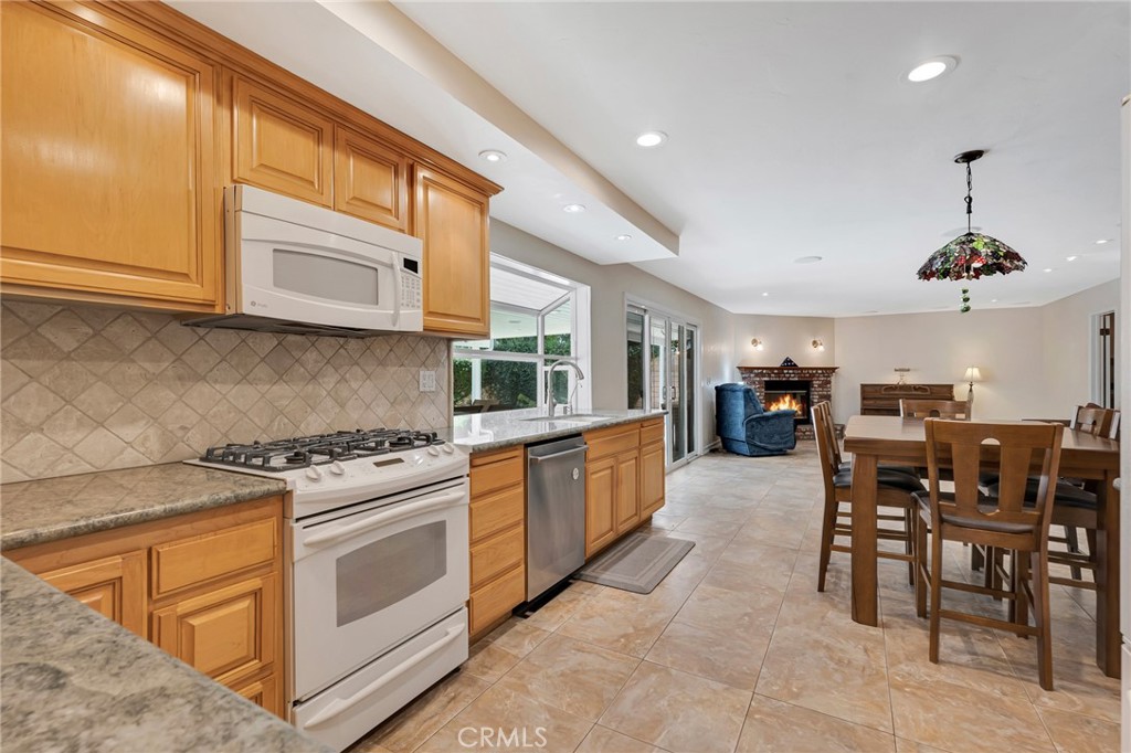 2146 North Brower Street Simi Valley, CA 93065 - Photo 26 of 51 a kitchen with stove a sink and chairs