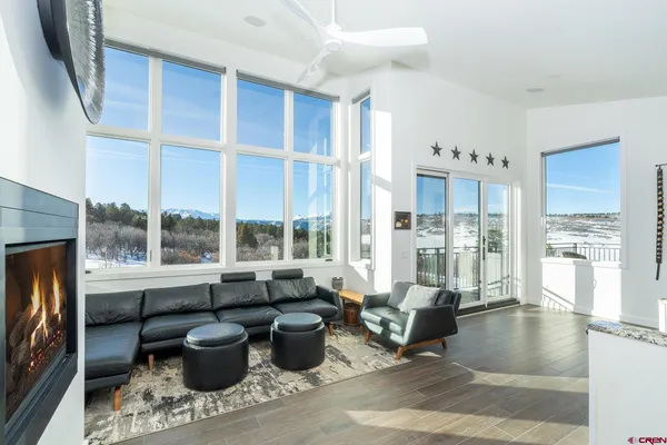 a living room with furniture a fireplace and a floor to ceiling window