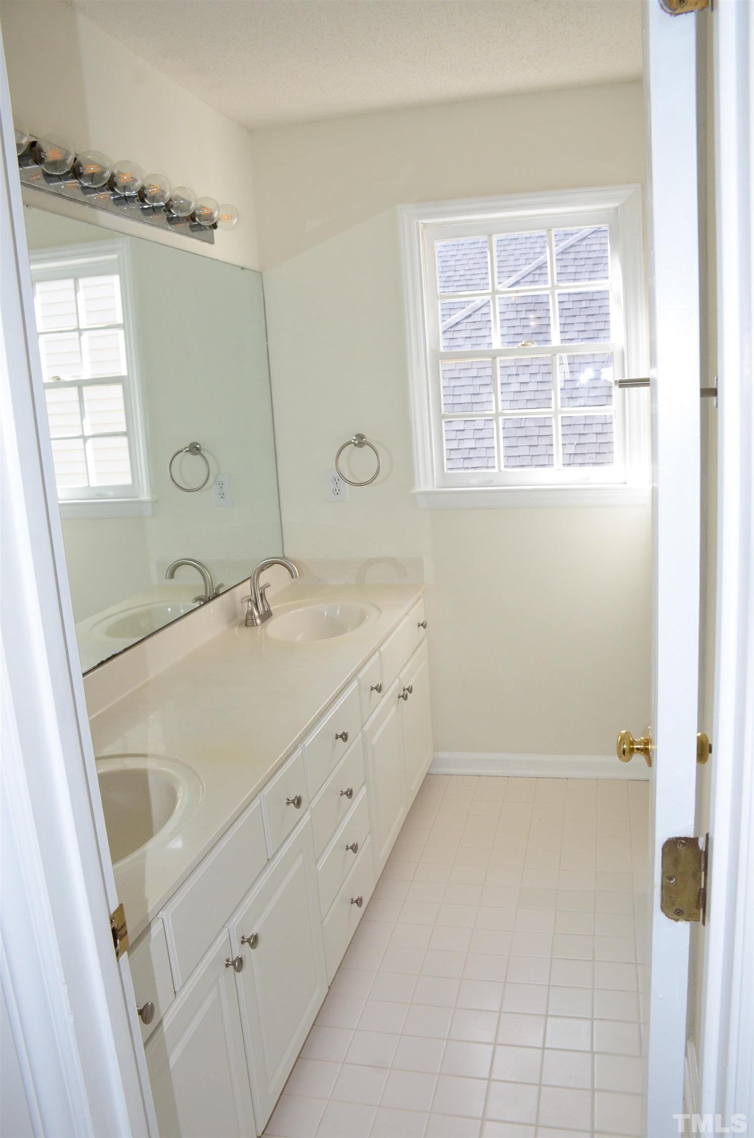 118 Covington Square Drive Cary, NC 27513 - Photo 29 of 58 a bathroom with a sink a mirror and a shower