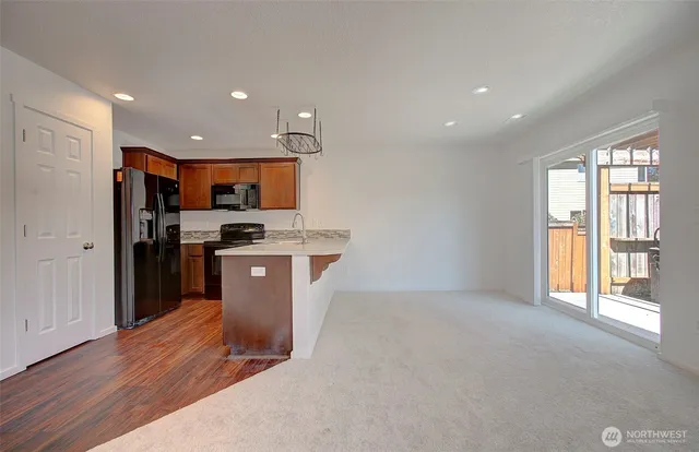 a kitchen with stainless steel appliances granite countertop a refrigerator a sink a stove and oven