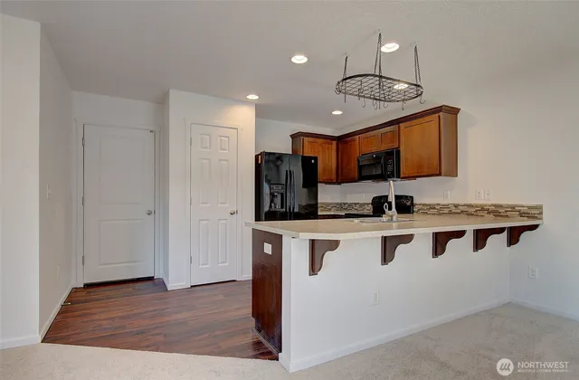 a kitchen with stainless steel appliances granite countertop a stove a sink and a refrigerator