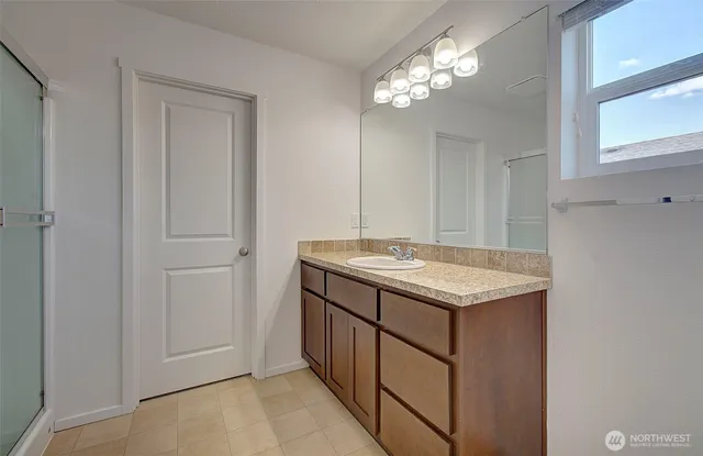 a bathroom with a granite countertop sink and a mirror