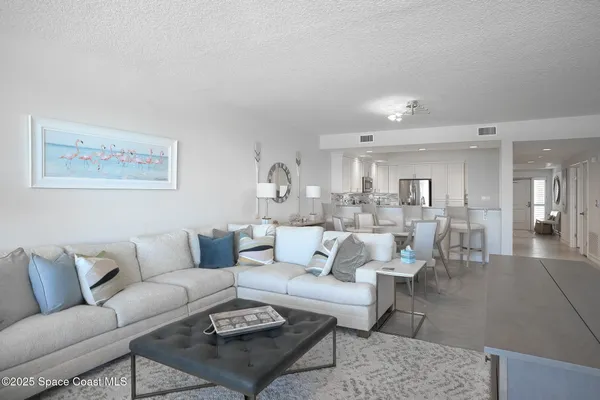 a living room with furniture and view of kitchen