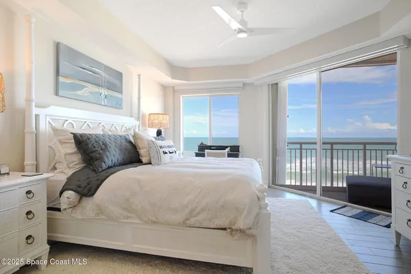 a bedroom with a balcony a bed and wooden floor