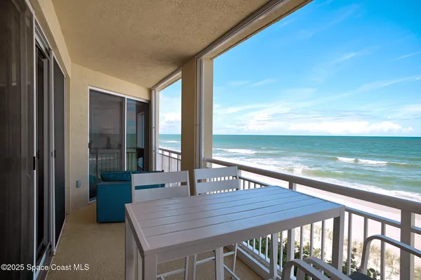 a view of a balcony with table and chairs